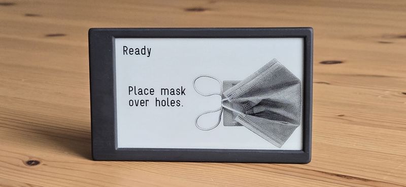A Canary displaying the words Ready, Place mask over holes, with a line drawing of a respirator mask.